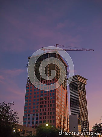 New Orleans, USA. December 2019. Working crane on a modern office building under construction during the sunset. Editorial Stock Photo