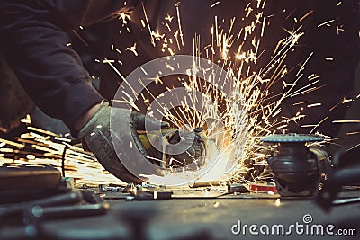 Working on cutting a metal tube with a sharp angle grinder with circular blade and generating sparks Editorial Stock Photo