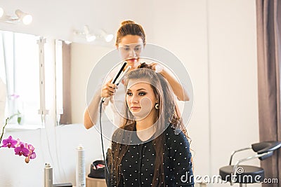 Working day inside the beauty salon. Hairdresser makes hair styling Stock Photo