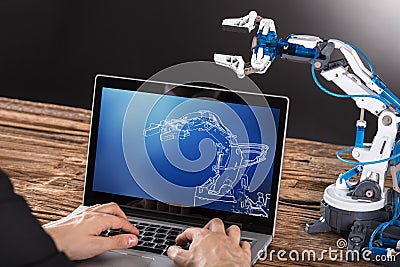 Working On Design Of Industrial Robot Arm On Laptop Stock Photo