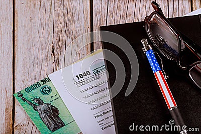 Working desk in the accountants office U.S. Individual income return tax 1040 form with glasses and pen and personal refund chec Editorial Stock Photo