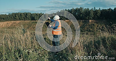 Working engineer in white helmet next to a sand pit. Foreman is talking on phone Stock Photo