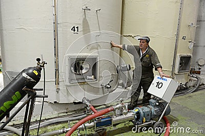 Working the fermenting vats of wine at the winery Santa Rita. Editorial Stock Photo