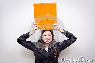 Working hard woman is holding the orange file above her head, showing her job is overloaded. concept for business Stock Photo