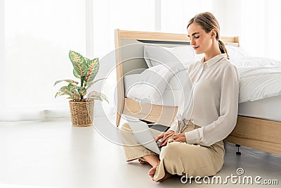 Working home concept.Pretty woman works from home or startup coworking space, sit on bed and writes code or blog or check mailbox Stock Photo