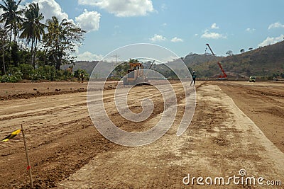 Working machines and heavy equipment adjust the terrain of the race track. Construction of the area and the Moto GP Mandalika Editorial Stock Photo