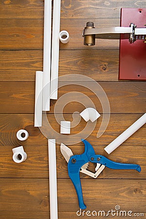 Working moment in the construction of home plumbing, white polypropylene pipes and tools of red soldering iron Stock Photo