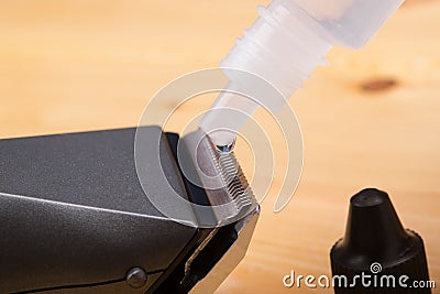 Working moment for maintenance of electric hair clipper, oil lubrication metal blades. Stock Photo