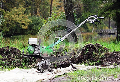 working motor-cultivator tiller in Gatchina park is on the ground waiting for work. Stock Photo