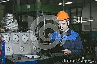 Working in the plant with tablet in hands on the background of t Stock Photo