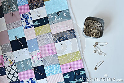 Working process: colorful quilt, metal jar and quilting pins Stock Photo