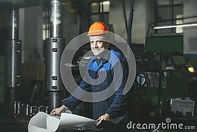 Working in production against a background of machines from the Stock Photo