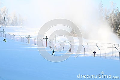 Working snow making machine on ski resort. Snow blower in action. Sunny winter day. Latvia Stock Photo