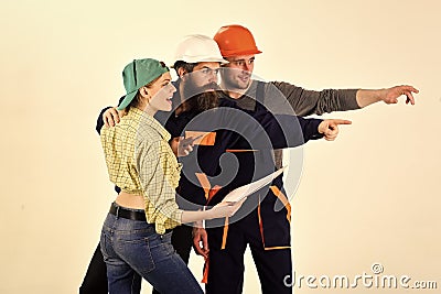 Working team. Brigade of workers, builders in helmets, repairers and lady discuss contract, white background. Brigadier Stock Photo