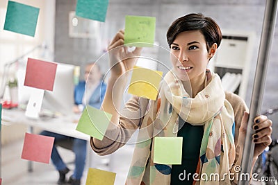 Working woman makes scheme on stickers at workplace Stock Photo