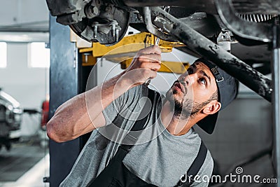 workman with equipment repairing car Stock Photo