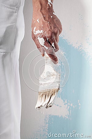 Workman Hand holding Dirty Paintbrush Stock Photo