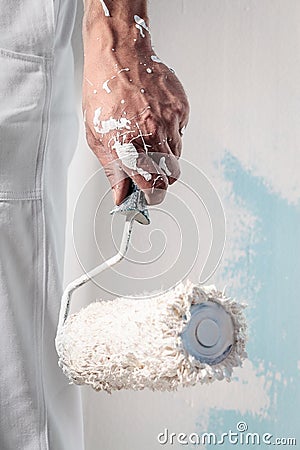 Workman Hand holding Dirty Paintroller Stock Photo