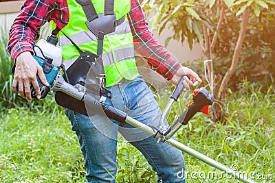 Workman holding lawn mower machine cutting grass Stock Photo