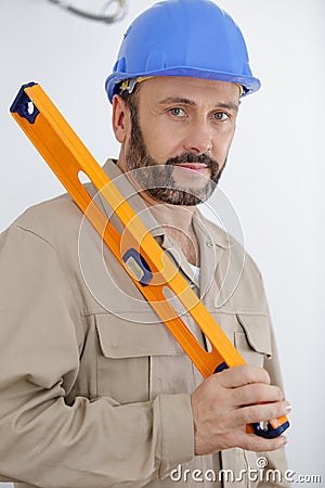 workman holding orange level Stock Photo