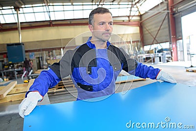 Workman holding sheet metal Stock Photo