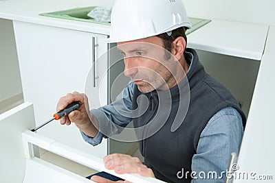 workman installing fitted kitchen Stock Photo