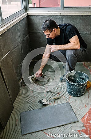 Workman laying tiles on a terrace Stock Photo