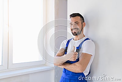 Workman in overalls showing thumb and smiling Stock Photo