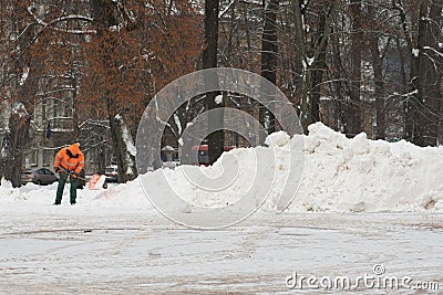 Workman with shovel at work in winter clearing snow Editorial Stock Photo