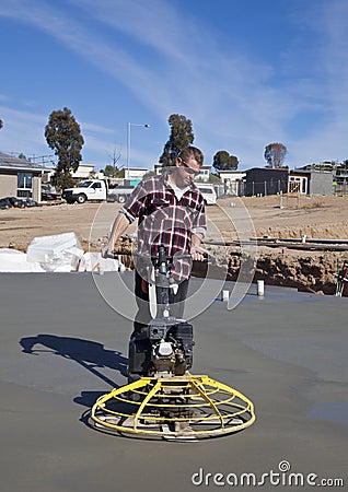 Workman smoothing newly poured concrete Stock Photo