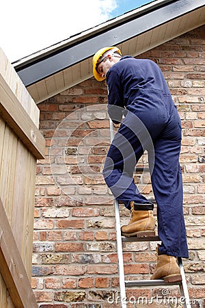 A workman up a ladder Stock Photo