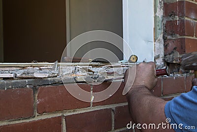 Workman using a hammer and chisel to remove old mortar Stock Photo