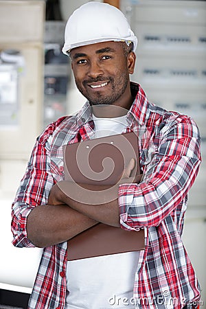 Workman wearing protective helmet and holding clipboard Stock Photo