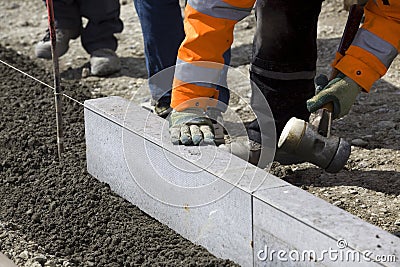 Workmen laying granite slabs Stock Photo