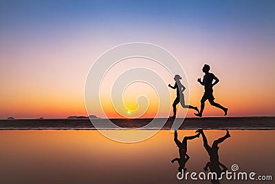 Workout, silhouettes of two runners on the beach Stock Photo