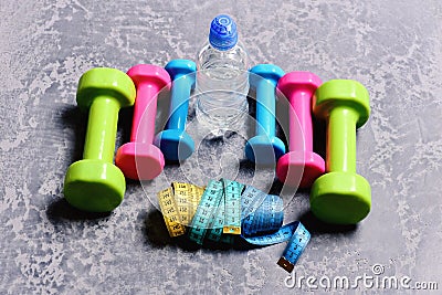 Barbells, colorful tape measures and water bottle placed in pattern Stock Photo