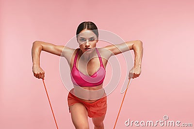 Workout. Woman Training With Resistance Bands On Pink Background Stock Photo