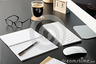 Workplace with computer, glasses and calendar on black wood table Stock Photo