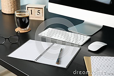 Workplace with computer, glasses and calendar on black wood table Stock Photo