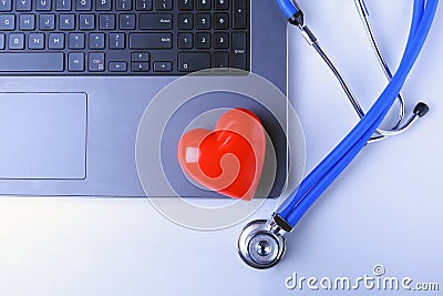 Workplace of doctor with stethoscope, red heart, laptop, rx prescription and notebook on white table. top view. Stock Photo