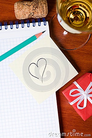 Workplace with gift, champagne and heart Stock Photo