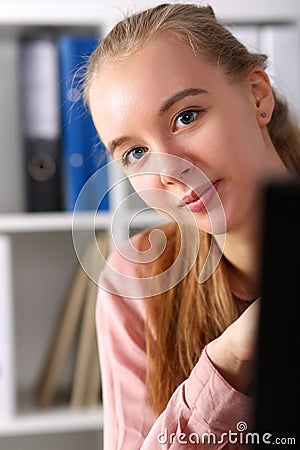 Workplace girl peeks out from behind monitor Stock Photo