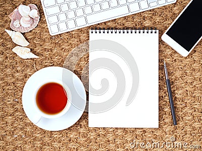 Workplace with laptop and blank notepad on mat. Top view. Flat lay. Freelance desktop, warm climate. Stock Photo