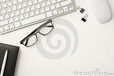 Workplace of office clerk. Frame border flatlay view photo of computer keyboard with paper clips leather diary eyewear isolated Stock Photo