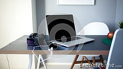 Workplace photographer and designer, laptop with camera and smartphone on the table. Stock Photo