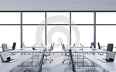 Workplaces in a modern panoramic office, copy space in the windows. Open space. White tables and black leather chairs. Stock Photo