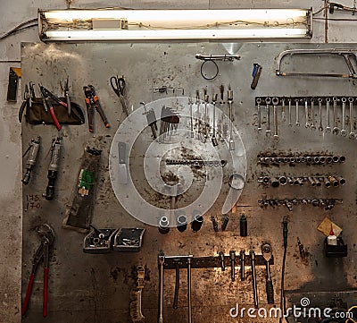 Workshop scene. Image of old tools hanging on wall in workshop. Vintage retro garage style Stock Photo