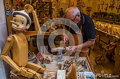 ROMA, ITALY - JULY 2017: Workshop where the master scrutinizes the handmade traditional wooden toys of Pinocchio Editorial Stock Photo