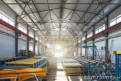 Worksop with machinery tools and equipment, conveyor line for production metal pipes and sandwich panels in factory interior Stock Photo