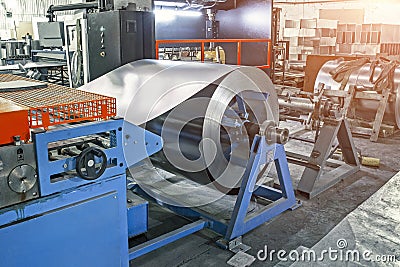 Worksop with machinery tools and equipment, rolls of galvanized steel for production metal pipes and tubes in factory Stock Photo